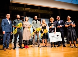 Pamiątkowe foto - na scenie stoi ośmioro nominowanych do Nagrody Literackiej im. Witolda Gombrowicza 2019, w tym gronie laureatka Olga Hund, za książkę „Psy ras drobnych”.