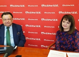 Podczas konferencji prasowej za stołem siedzą uczestnicy konferencji prasowej, po lewej marszałek Adam Struzik i po prawej członek zarządu Janina Ewa Orzełowska. Za nimi ścianka reklamowa z logotypem Samorządu Mazowsza.