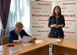 Występuje stojąc Janina Ewa Orzełowska, po lewej siedzi za stołem Elżbieta Lanc.