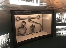 Obiekt muzealny. Kajdany, wyeksponowane w szklamnej gablocie.