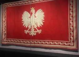 Obiekt muzealny. Gobelin z wizerunkiem godła II Rzeczpospolitej, białego orła na czerwonym tle.