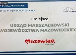 Zrzut ekranu komputera z transmisjii on-line. Slajd z informacją o zwycięstwie miesięcznika Mazowsze.serce Polski