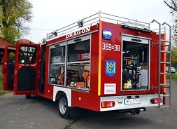Zdjęcie przedstawia wóz strażacki z otwartymi drzwiami i wszystkimi schowkami, w których znajdują się elementy sprzętu ratowniczego.