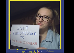 Dziewczyna w okularach trzyma przed sobą kartkę z napisem Unia Europejska to prawa człowieka