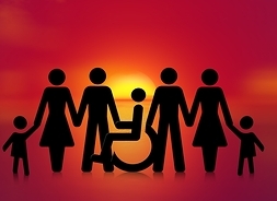 Sylwetki kobiet i mężczyzn na kontrastowym tle, op środku wózek inwalidzki