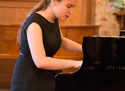 Artystka gra na fortepianie podczas koncertu w Płocku