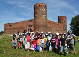 grupa dzieci przed Zamkiem Książąt Mazowieckich w Ciechanowie