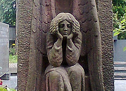 rzeźba siedzącego zamyślonego anioła