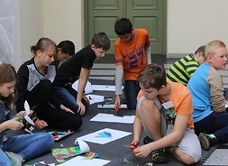 Grupa dzieci wycinających z kartonu kolorowe wzory