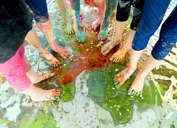 Nagie nogi grupy dzieci umazane kolorowymi farbami