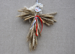 Figurka anioła do zawieszenia na choince, zrobiona ze słomy, papieru, wstążki i włóczki.