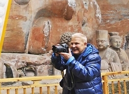 Plakat przedstawiający kobietę z aparatem fotograficznym