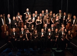 39-osobowa orkiestra w strojach wieczorowych z instrumentami