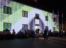 Piętrowy budynek nocą oświetlony laserem w kwadratowe wzory i kolorowe pasy