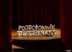 Scena z odsłoniętą kurtyną. Na scenie w dwóch rzędach usytuowany napis Pojeciownik teatralny.
