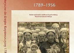 Okładka książki zawierająca archiwalne zdjęcie przedstawiające grupę kobiet z dziećmi w strojach regionalnych, trzymające w rękach bukiety z kwiatów i ziół.