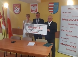 Podpisanie umowy z gminą Rusinów wicemarszałek Rajkowski i wójt Rusinowa trzymają czek na 223 tysiące złotych